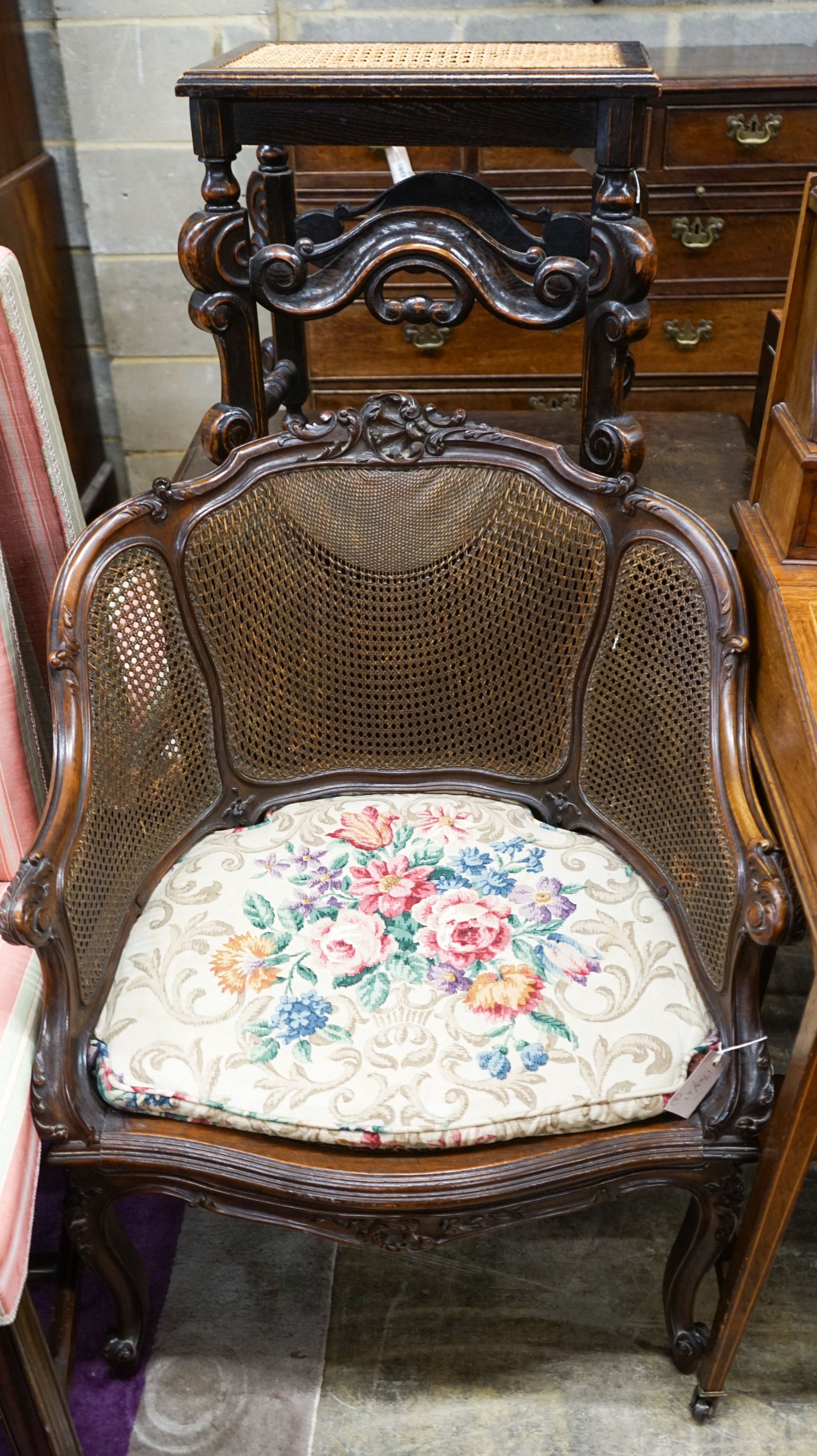 A French style carved walnut frame bergere with caned panels on cabriole legs, length 70cm, depth 52cm, height 86cm together with a Carolean style caned stool